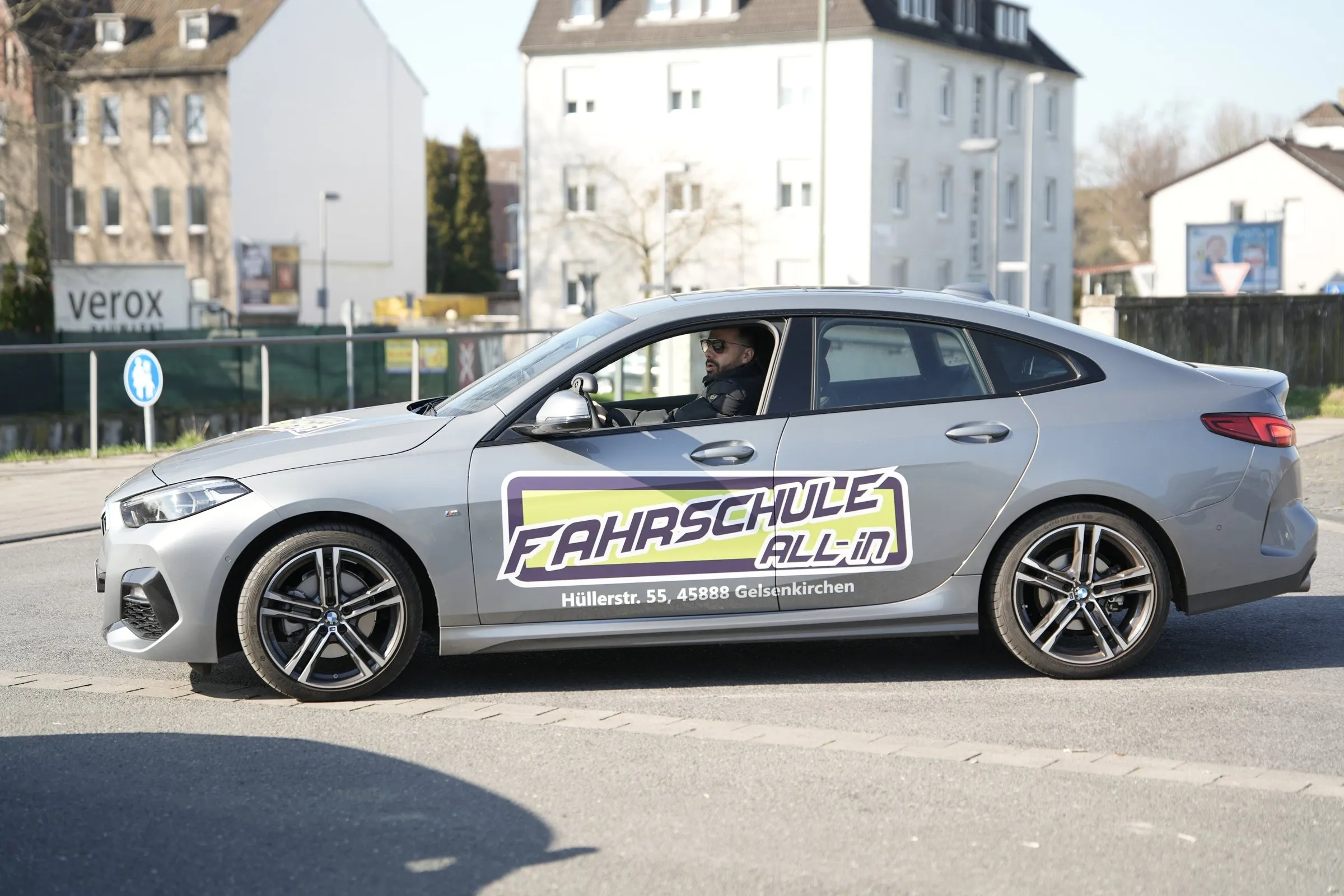 Grauer BMW 2er der Fahrschule All-in in Fahrt