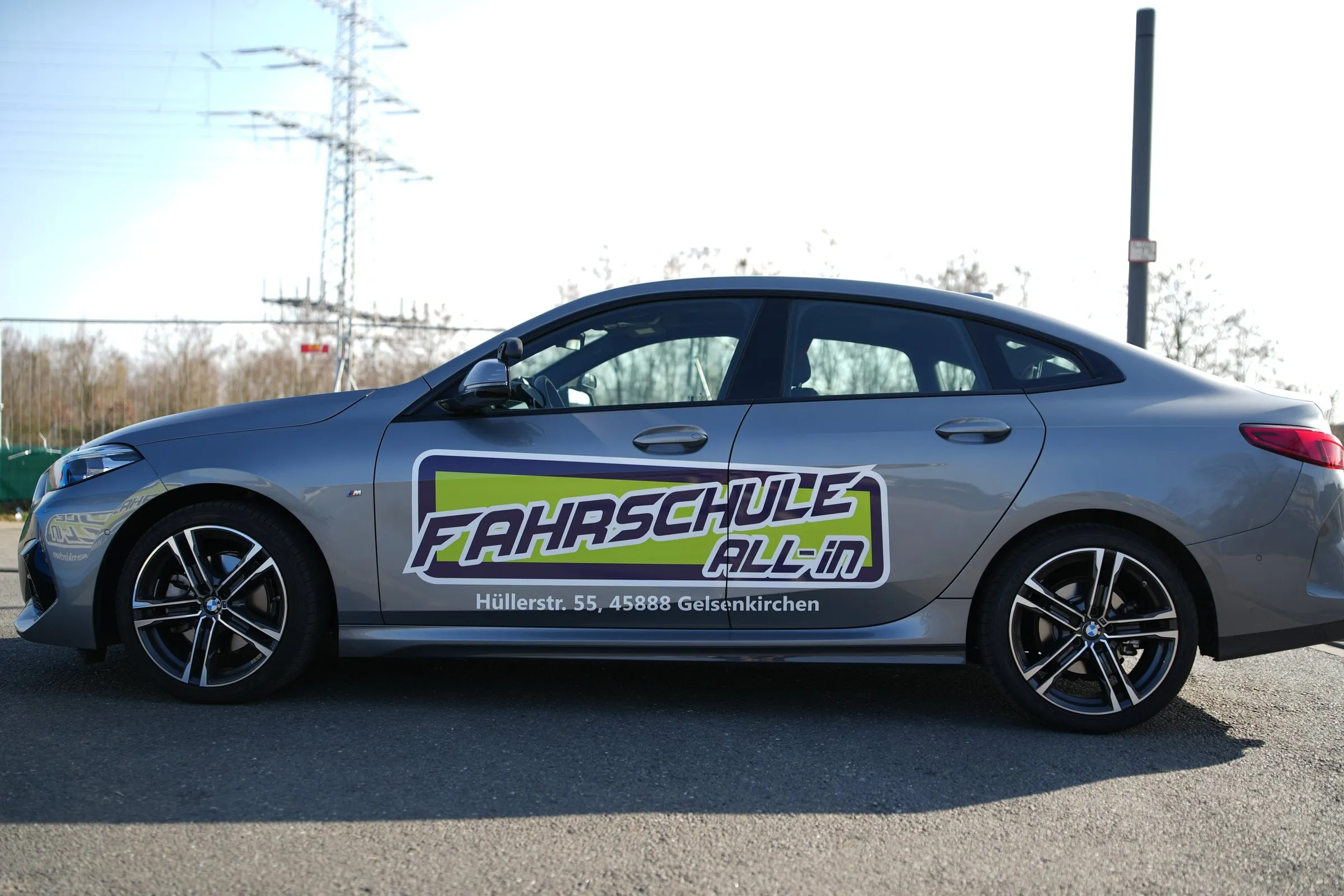Grauer BMW 2er Gran Coupé der Fahrschule All-in von der Seite