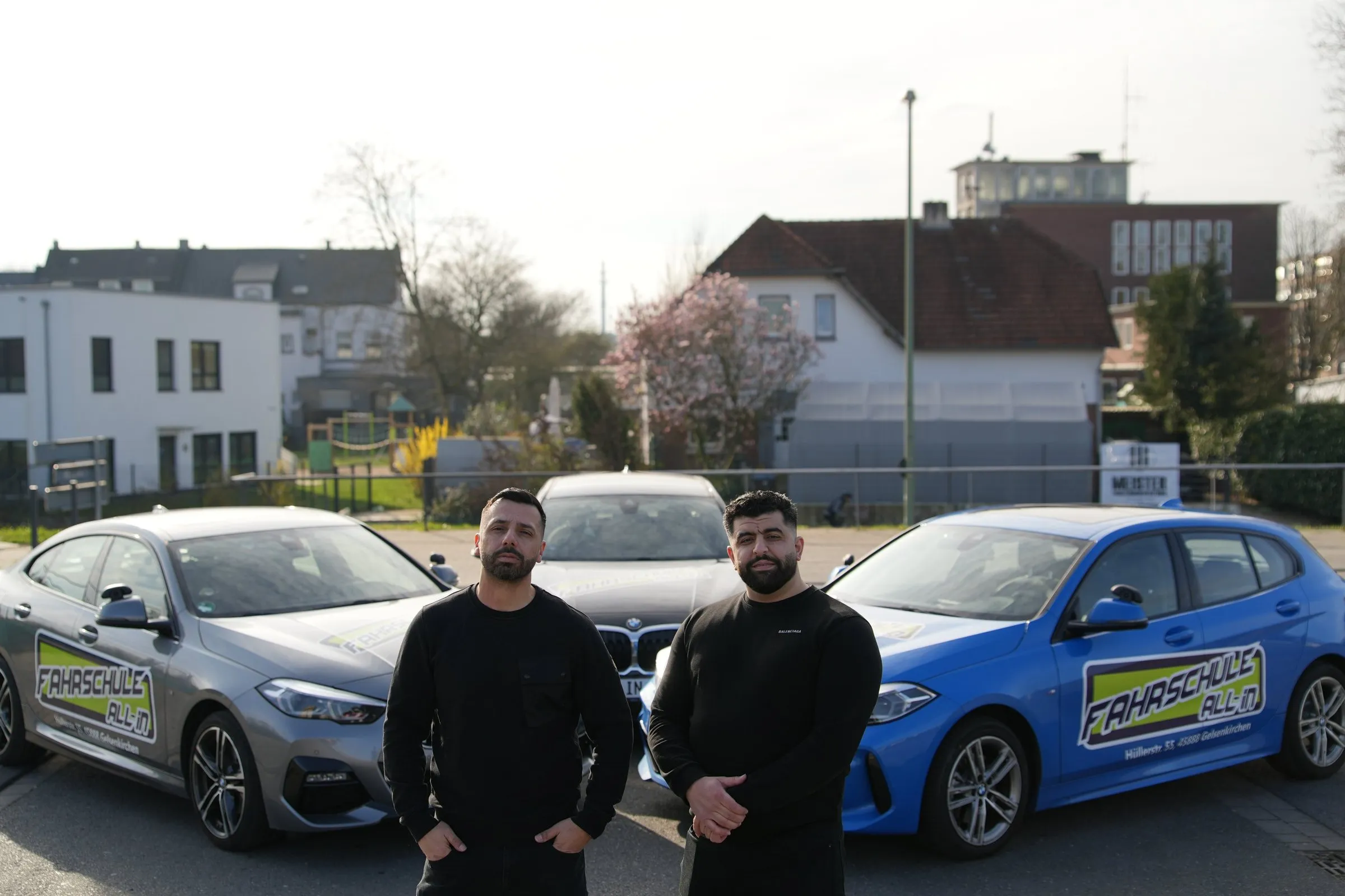 Zwei Mitarbeiter der Fahrschule All-in vor der Flotte